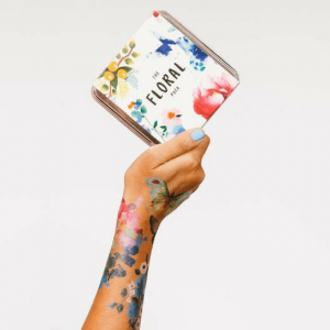 Throw A Tattoo Party (It's Not What You're Thinking) - floral Tattly tattoos on an arm holding a book