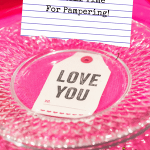 Pinterest title image - clear plate on pink tablecloth with "love you" on tag under plate