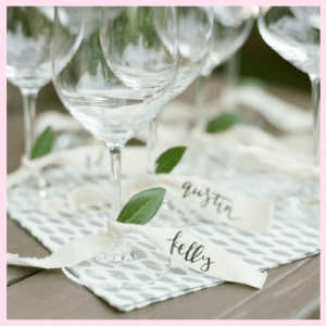 personalized ribbon tied around stem of wine glasses