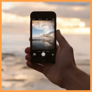 15 Best Trip Planning Hacks To Help You Save! - hand holding a cell phone with scenic view of ocean