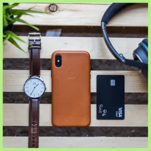 15 Best Trip Planning Hacks To Help You Save! - watch, cell phone, credit card and headphones layed out on a table