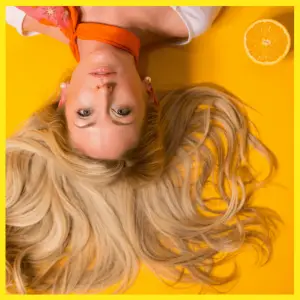 10 Online Fashion Stylists Almost Haute-Couture - girl lying down with blond hair on a yellow background
