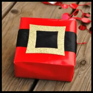 Gift Wrapping: The Presentation Of Presents! - gift wrapped in red paper with a black band and gold buckle