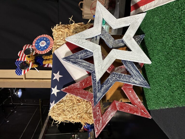 red, white and blue large stars with a dog on a bail of hay